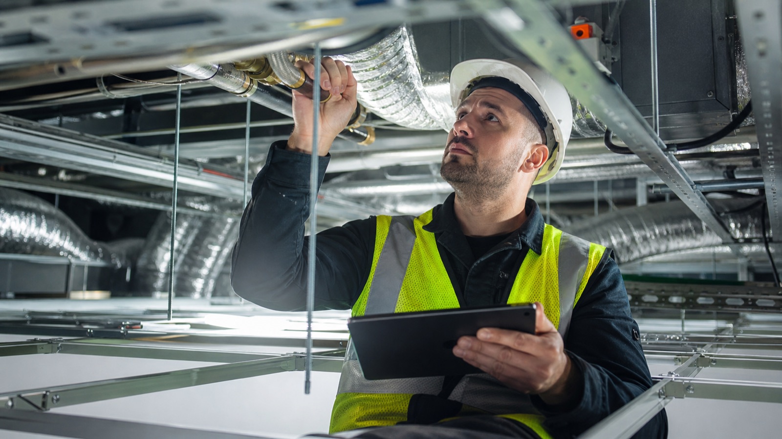 Building services engineer reviewing MEP systems inside a modern commercial building